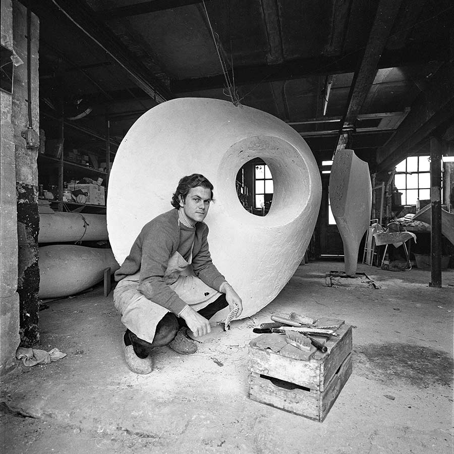 The sculptor Lucien den Arend posing with plaster model for discoid form III.
